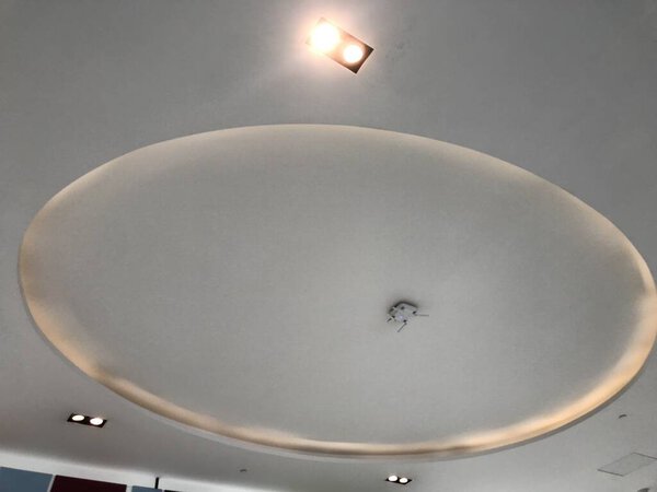 Circle or round gypsum false ceiling with coves with indirect lighting at center of an retail shop