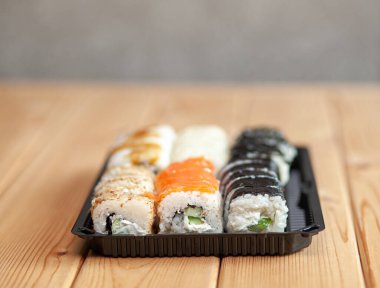 Evde suşi ve ekmek yapıyorum. Deniz mahsullü suşi, salata ve beyaz pirinç. Aile ve arkadaşlar için yemek. Tepside farklı rulo ve suşi seti..