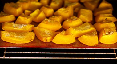 Fırında kabak dilimleri fırında pişiyor. Ev yapımı yemekler, vejetaryen yemekleri, sağlıklı yiyecekler, turuncu sebzeler, fırın tepsisi ve peçete, fırında pişmiş sebzeler, pop sanat, diyet sırasında tatlı.