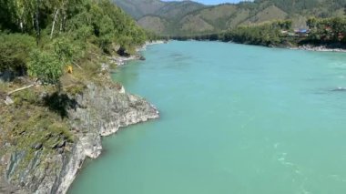 Hızlı akan geniş ve tamamen akan bir dağ nehri. Büyük kayalar sudan dışarı çıkar. Büyük dağ nehri Katun, turkuaz renk, Altai Dağları, Altai Cumhuriyeti.
