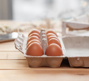Büyük bir karton torbanın hücreleri arasında birkaç kahverengi yumurta, değerli bir besleyici ürün olarak bir tavuk yumurtası, kırılgan yumurtaları taşımak ve depolamak için bir tepsi. Bir paket yumurta, önemli bir yiyecek.