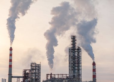 Ağır endüstriyel Petrokimya fabrikası, duman kirliliğiyle enerji rafinerisi üretimi. Fabrikanın bacasından yoğun duman geliyor. duman bulutu emisyonları kötü ekoloji hava fotoğrafçılığı
