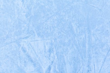 Açık hava seansından sonra buz pateni izleri olan boş bir buz pisti. Gün ışığında buz pateni pisti dokusu karla kaplı. Mavi buz pateni pistini kapatın, boşluğu kopyalayın