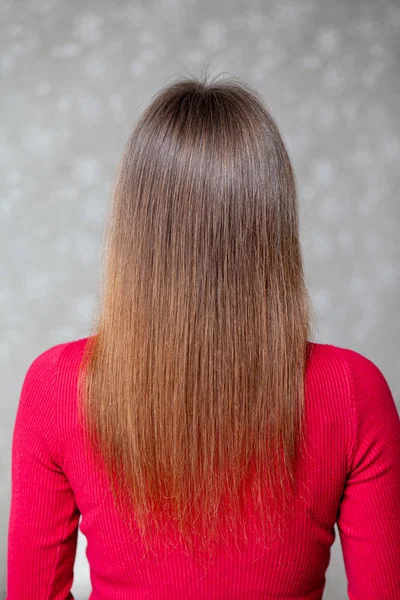Девушка с длинными, прямыми и красивыми каштановыми волосами. Уход за волосами на дому — стоковое фото