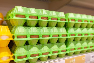 Mağazada yumurtalarla dolu büyük bir raf. Yerel bir dükkanda satılık büyük bir tavuk yumurtası koleksiyonu..