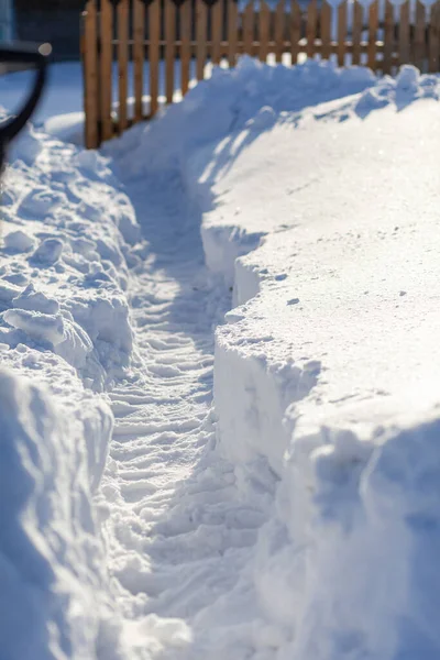 一个人在大雪中挖了一条通道 在冬天大雪之后 把雪清除到房子和栅栏上 — 图库照片