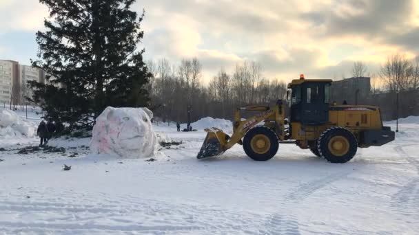 2022 러시아의케 트랙터가 크리스마스 광장에 조각상을 겨울에 치우는 — 비디오