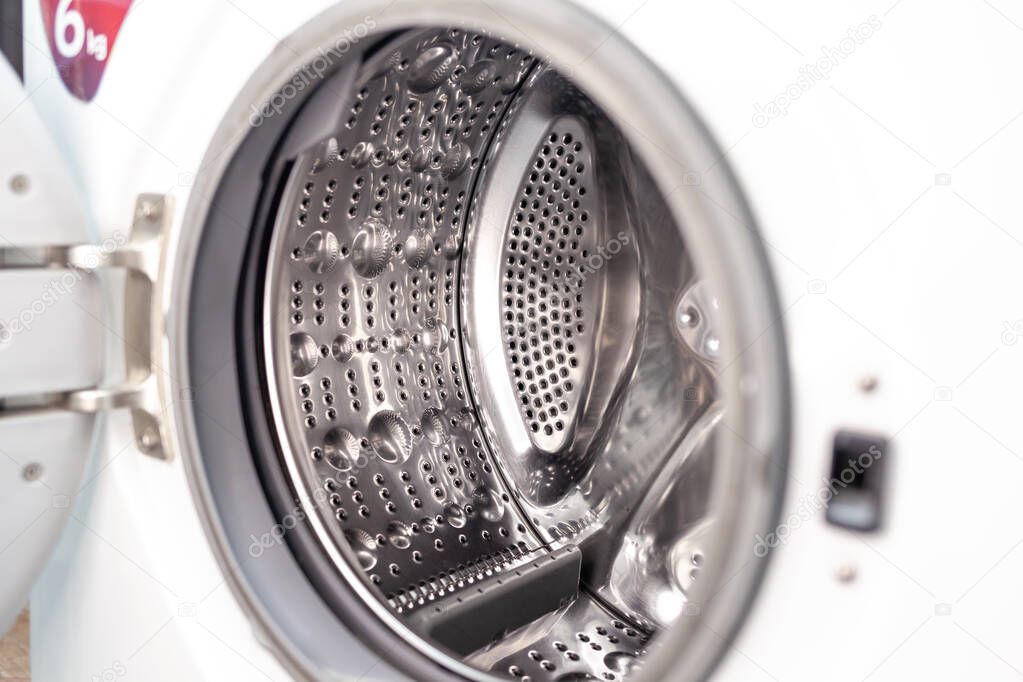 The washing machine drum is dry and clean close-up. Washer