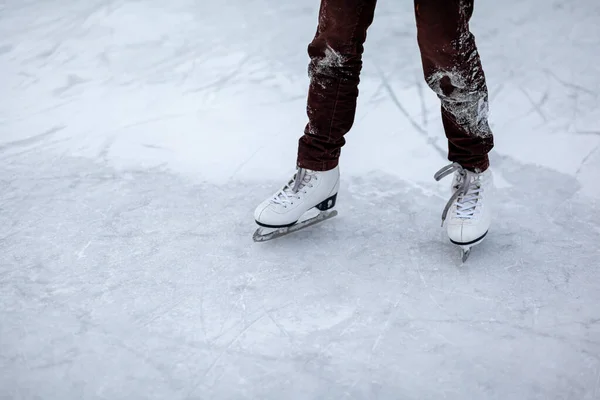 凍った氷の上にレースを持つ白いフィギュアスケートのペアを閉じます 男がスケートをしている 冬にはアイススケートやホッケーをプレイ 氷と脚をスケートのマークで氷の背景にコピーし — ストック写真