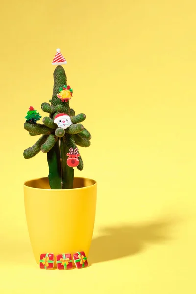 Kaktus dihiasi dengan simbol-simbol Natal kecil sebagai pohon Natal alternatif dengan warna kuning. Orientasi vertikal. — Stok Foto