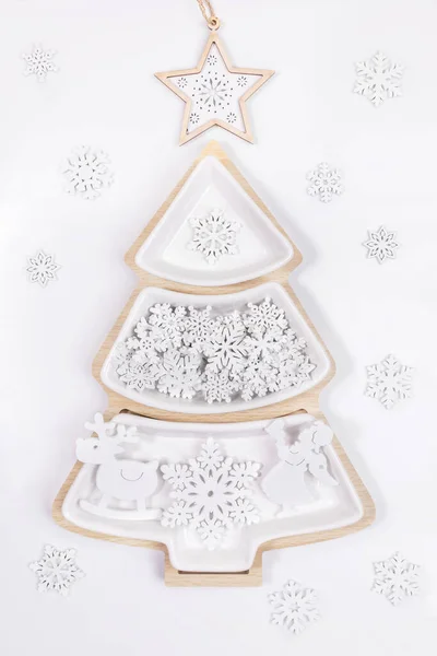 Placa de madera como árbol de Navidad con decoraciones blancas de Navidad y copos de nieve y estrella en la parte superior en blanco. — Foto de Stock