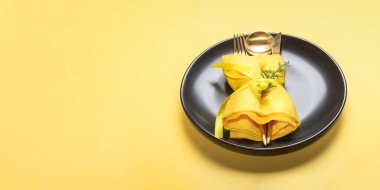 Xmas tebrik kartı ya da davetiye. Altın çatal bıçak, kaşık, çatal, çatal, sarı arka planda yuvarlak siyah tabak. Boşluğu kopyala.