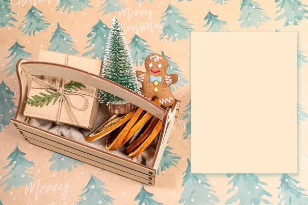 Caja de madera con decoraciones navideñas y hoja de papel vacía sobre fondo festivo. Se burlan de las vacaciones. — Foto de Stock