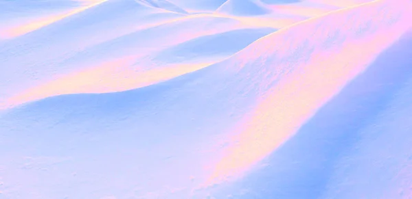 要旨トーン冬の背景 ネオンピンク 金色のシュールなイメージ 白い雪のドリフトの起伏のある斜面に光と影の再生 — ストック写真
