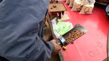 Sıcak nohutları kumda ısıttıktan sonra kese kağıdına koymak Pakistanlı ve Hint sokak yiyecekleri.
