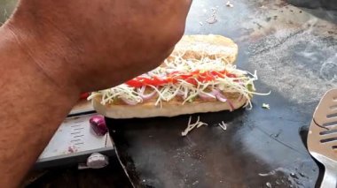 Hamburgerler çörekler, pirzolalar, sebzeler ve sostan yapılır. Çocuklar için festival menüsü. Domates ketçapını çöreğin üzerine koyan şefin elleri..