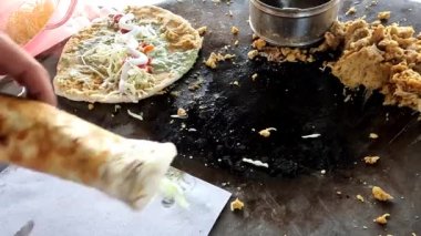 Naan tikki rulolarını kağıda sarmak, baharatlı pakistanlı ve Hint sokak yemeklerine sarmak