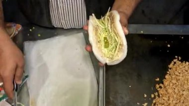 Şefin elleri pide ekmeğine tavuk eti koyuyor. Ekmek, shawarma, pita ekmeği. Sebze karışımı. Dışarıda shawarma pişiriyorum..