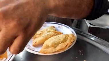 Şefin yakın görüşü Samosa sohbeti, Pakistan ve Hindistan sokak yemekleri için tabakta samosa kırmak veya ezmek