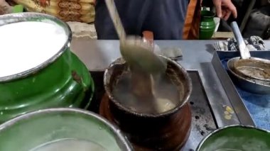 Köfte otelinde çay yapan, çay karıştıran, Pakistan sokak yemekleri yapan bir adam.