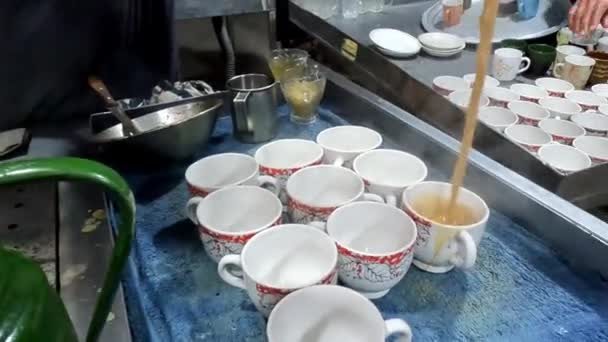 近距离拍摄的男子的手 他把茶倒在杯子里 在桌上的托盘里 帕基斯塔尼酒店的茶 — 图库视频影像
