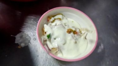 Chana Chaat 'ın üzerine papri dökerek, Pakistan sokak yemeklerinde servis yapmaya hazır, yol kenarında.