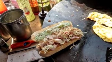 Hamburger pişirirken ızgara ekmeğe yumurta ve hamburger koy, yüksek açılı.