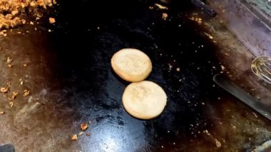 Hamburger ekmeğine mayonez serpiştirmek. 4K kısa video klibi.