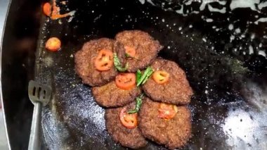 Güzel ve lezzetli chapli kebap üst yakın çekim dekorasyon kızarmış domates ve yeşil chilli 4k yüksek çözünürlüklü video