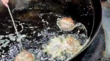 Büyük kızgın yağ tavasında chapli kebap çevirme ve yağ 4K yüksek çözünürlüklü video içine domates ekleme