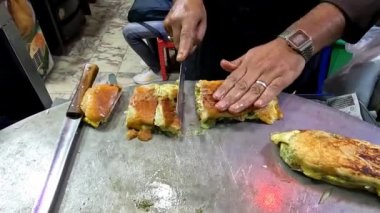 Tavada yumurtalı shami burgerin büyük bıçaklı 4k çözünürlüklü video görüntüsü.