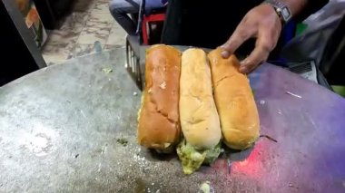 Dev pan 4k çözünürlüklü videoda üç yumurtalı shami burger ısıtıyorum.