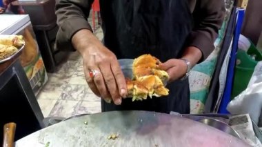 Dilimlenmiş yumurtalı shami burgeri ketçap ve yeşil nane soslu 4K çözünürlüklü video ile servis edilen tabağa koyuyorum.
