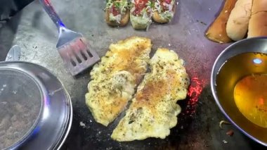 Büyük bir tavada yumurta dilimleyip 4K çözünürlüklü hamburgerin üstüne koymak.