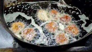 Chapli Kebap 'ın 4K çözünürlüklü büyük bir tavada kızartılışının üst görüntüsü.