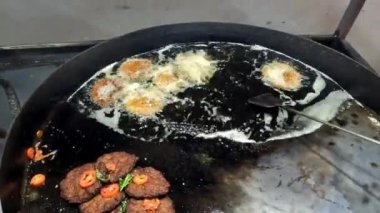 Chapli Kebap 'ın 4K çözünürlüklü büyük bir tavada kızartılışının üst görüntüsü.