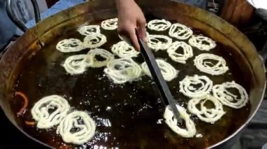 Pakistan, Pakistan ve Orta Doğu 'da kızgın petrol caddelerinde jalebi yapmak ya da kızartmak. Jalebi geleneksel tatlı bir spiral şeklindedir.