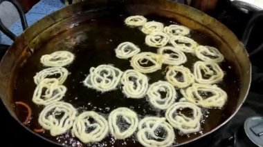 Pakistan, Pakistan ve Orta Doğu 'da kızgın petrol caddelerinde jalebi yapmak ya da kızartmak. Jalebi geleneksel tatlı bir spiral şeklindedir.