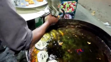 Adam Pakistan 'da bir sokak yiyecek pazarında geleneksel jalebi atıştırmalıkları yapıyor.