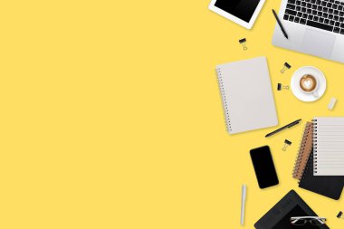 dizüstü bilgisayarı, ofis malzemeleri, kahve fincanı, tablet ve cep telefonlu düz çalışma masası