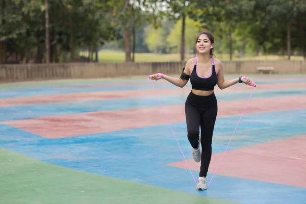 경기를 아시아 여자가 운동을 줄을건너뛰고 활동적 소녀는 배경을 이두근 운동을 — 스톡 사진