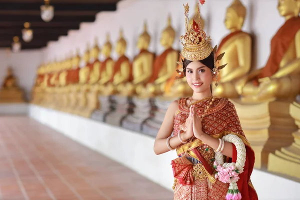 赤いタイの伝統衣装を着た若いファッションと美しいアジアの女性は タイの古代仏教寺院Ayutthayaに立ってジャスミンの庭を保持しながら 敬意Sawasdeeシンボルを支払います 旅行のコンセプト — ストック写真