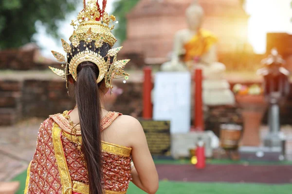 タイの赤い伝統衣装を身に着けているリアビューのファッションと美しいアジアの女性は タイの古代寺院Ayutthayaで幸せと平和立って屋外でジャスミンガーランドを保持しています 旅行のコンセプト — ストック写真