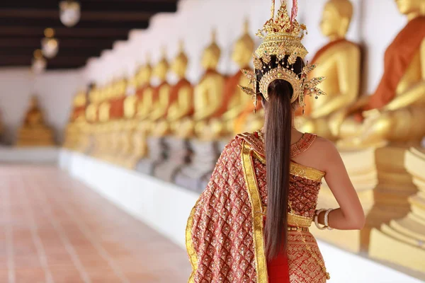 リアビュー赤いタイの伝統的な衣装で若いファッションアジアの女性は 古代の仏教寺院Ayutthaya Thailandに立ってジャスミンのガーランドを保持しながら敬意Sawasdeeシンボルを支払います 旅行のコンセプト — ストック写真