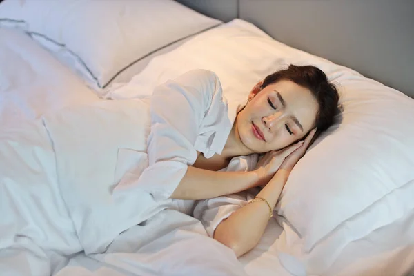 夢を見ながら 幸せと笑顔でベッドルームで寝そべっている白い寝具を身に着けているアジアの女性が寝そべっているトップビュー ライフスタイルコンセプト — ストック写真