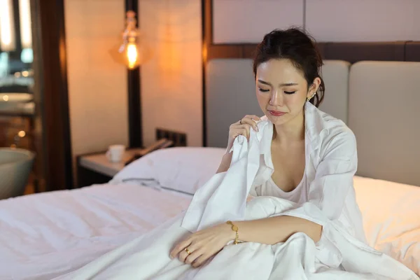 低光環境でホテルのベッドルームでベッドで泣いている間 若い落ち込んでアジアの女性が座ってハンカチを保持します 悲しい女の子 不幸と孤独の概念 — ストック写真
