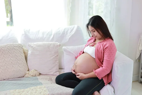 Šťastná Usměvavá Mladá Asijská Těhotná Žena Sedí Odpočívá Pohovce Obývacím — Stock fotografie