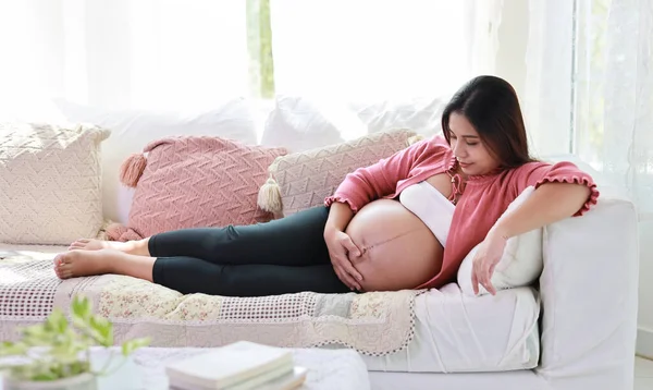 Šťastná Usměvavá Mladá Asijská Těhotná Žena Odpočívající Ležící Pohovce Obývacím — Stock fotografie