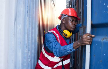 Foreman içerideki malları görmek ve yükleme kutularını kontrol etmek için konteynır kapısını açar. Konteyner kargo alanında çalışan mühendis ya da işçi endüstriyel konteynır kargo gemisini kontrol ediyor..