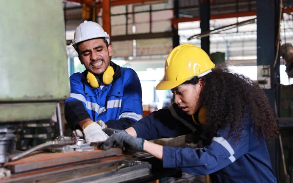 Genç teknisyen ya da işçi üniformalı işçi metal torna fabrikasındaki torna makinesinde el kazası geçirdi. Güvenlik meslektaşı ekibi kazadan kurtulmasına yardım ediyor. İlk yardım eğitim kavramı